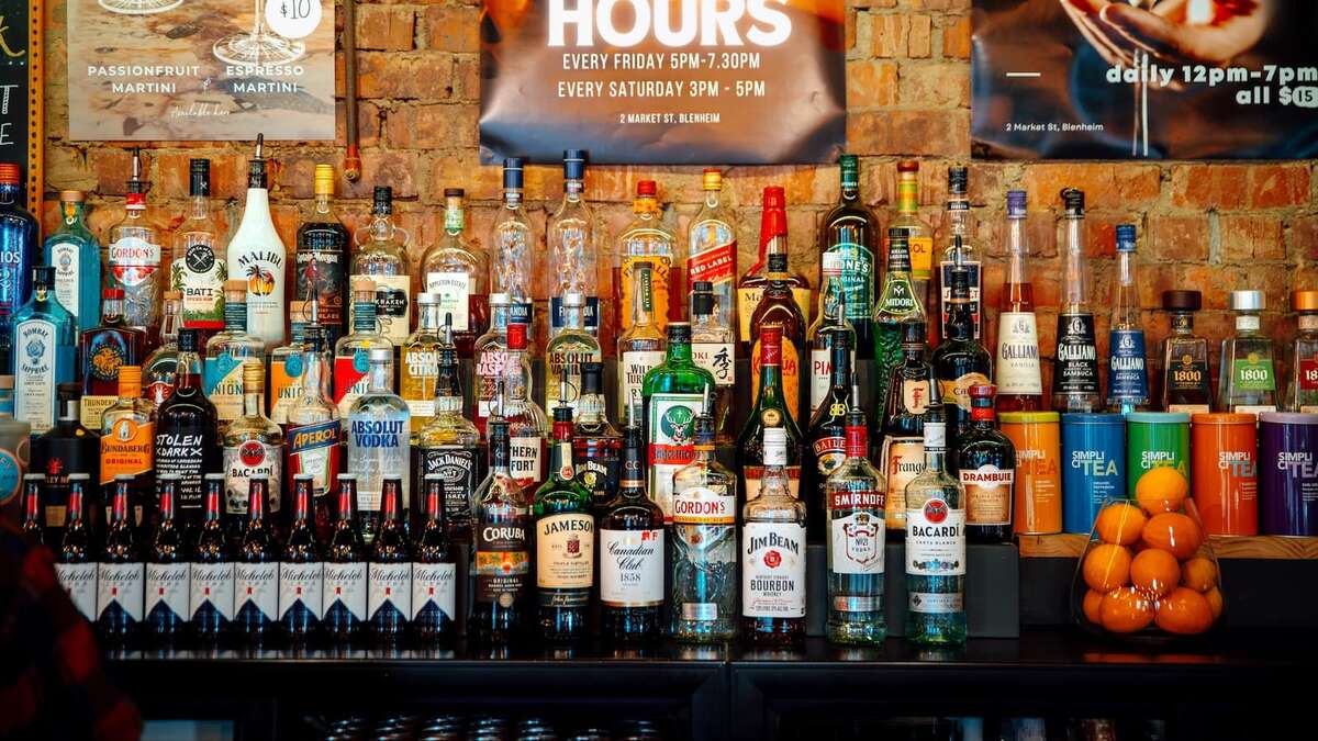 The fully stocked back bar at Biddy Kate's, Blenheim, rows of spirits against an exposed brick wall